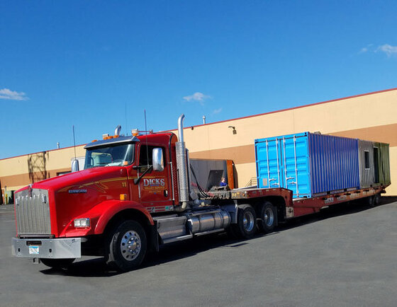 Truck delivering a blue shipping container