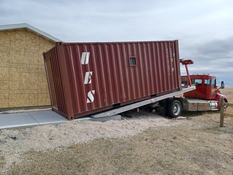 20 container being delivered on a cement pad