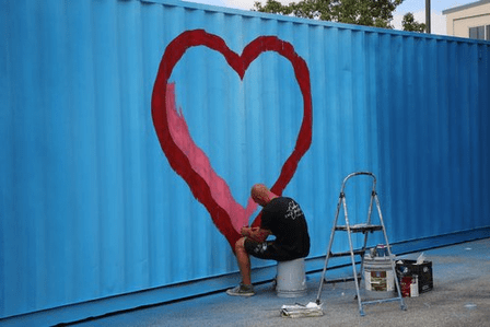 Artist Zack Smithey paints the shipping container soon-to-be “Unity Art Sukkah” during the Second Annual St. Charles Jewish Festival in mid-August of this year. Credit: Chabad Jewish Center of St. Charles County
