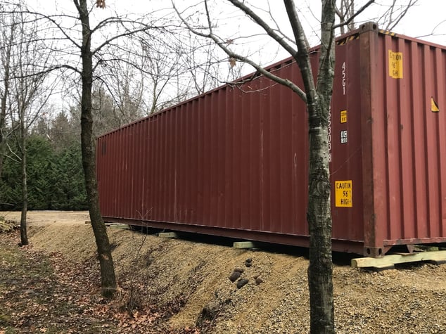 Red container in woods with wood blocks