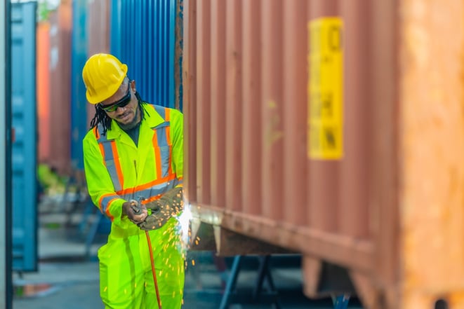 welding technician modifying shipping container