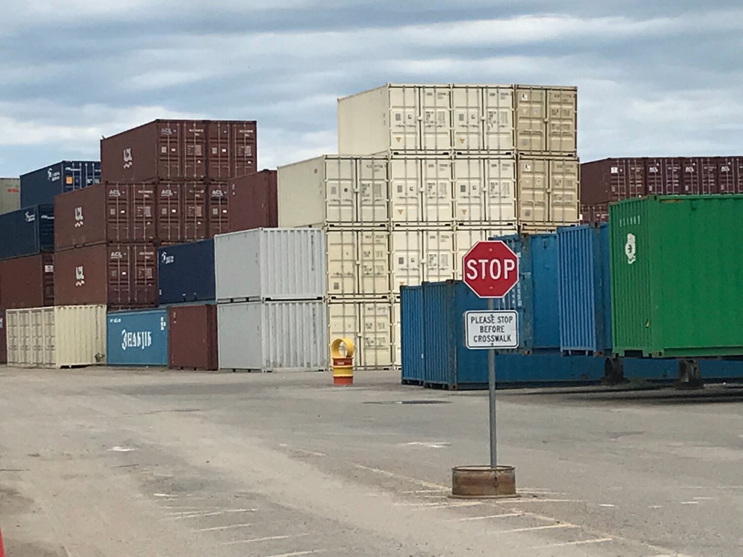 cream colored containers stacked in a depot yard
