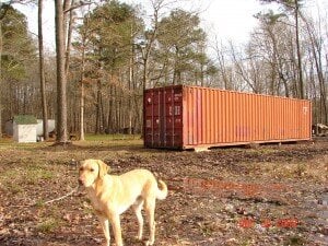 a yellow lab standing in front of an orange storage container