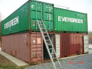two shipping containers stacked with a ladder
