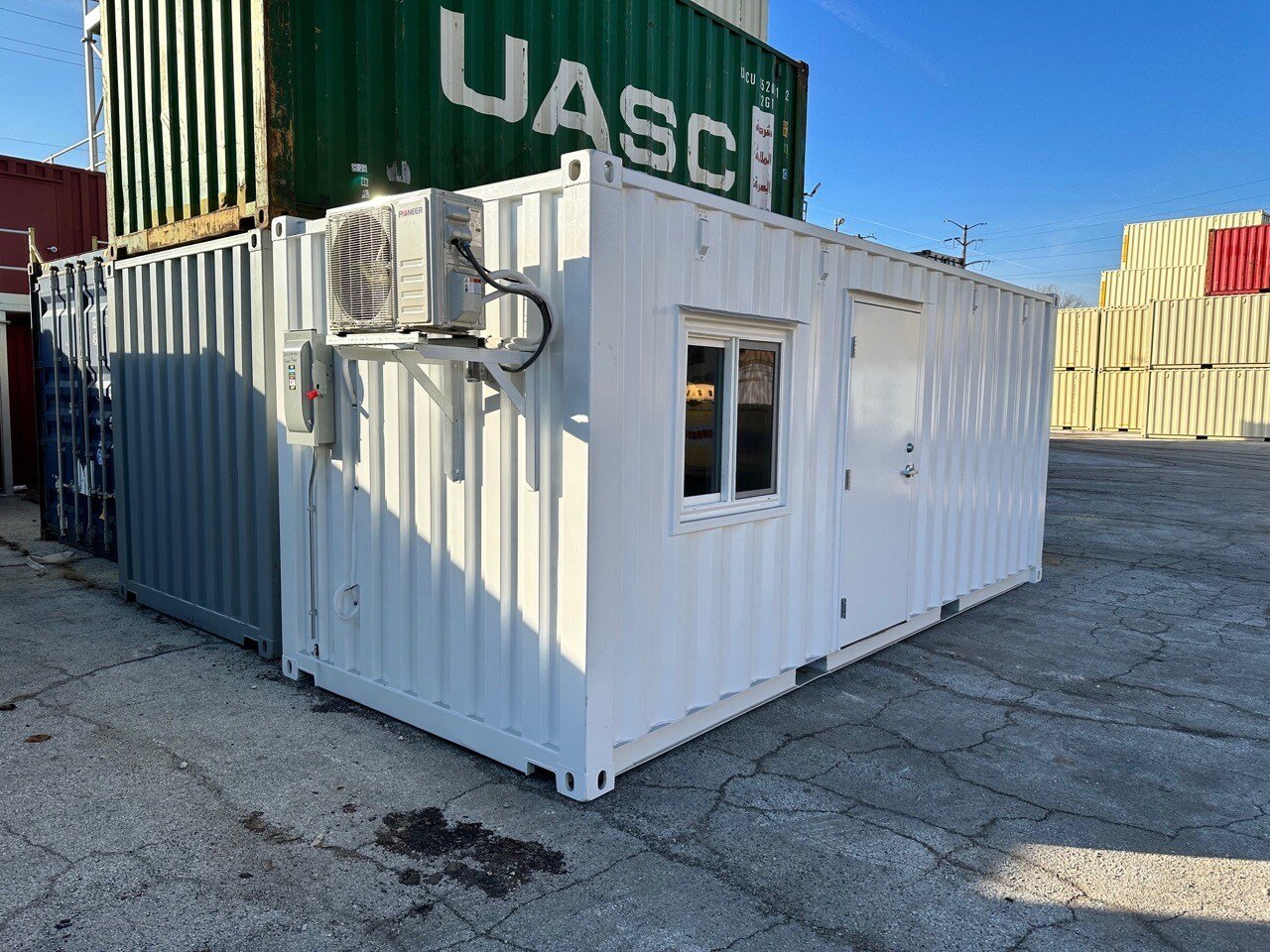white shipping container with modifications including door, windows and HVAC